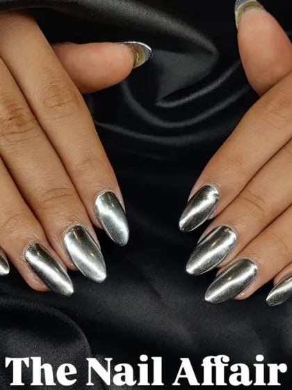 A full set of high-shine silver chrome nails. This manicure uses a special powder to create a liquid metal effect, resulting in a futuristic and incredibly eye-catching look on almond-shaped extensions.