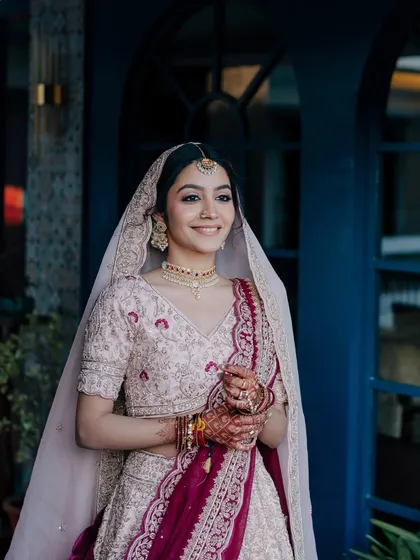 The magic of a first look. This bride's soft smile and glowing skin in her pastel lehenga create a moment of pure, unscripted joy.