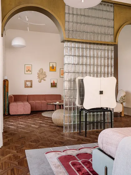This image captures a collection of our unique seating and table designs. From a plush, channel-tufted sofa to a sculptural lounge chair made of upholstered stone, each piece is designed to be a work of art.