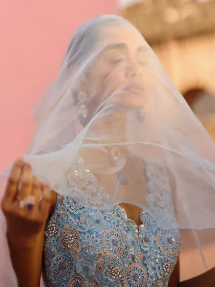 A beautiful, artistic shot with a sheer veil. The intricate beadwork on the blouse from the Awigna campaign is highlighted here.
