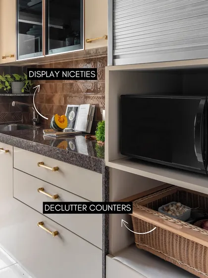 This image provides great tips for kitchen styling. Decluttering counters and using baskets for storage keeps the space tidy, while displaying nice ceramics and cookbooks adds a personal touch.