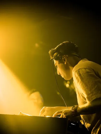 A focused, atmospheric shot of me working the turntables under a single spotlight. It highlights my dedication to the craft of DJing.