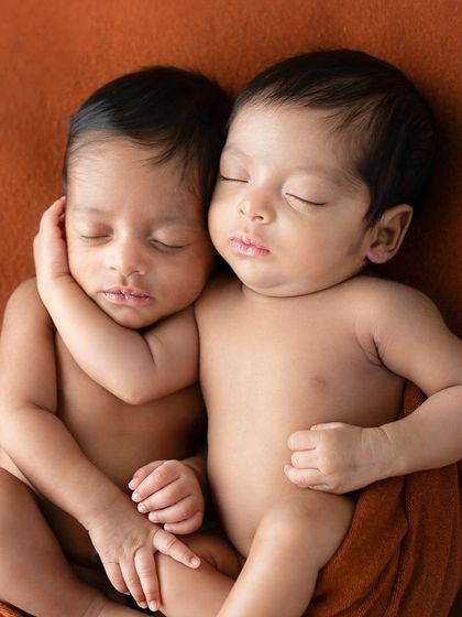 A stunning portrait of newborn twins embracing in their sleep. The image captures the comfort and security they find in each other, a bond that started long before they were born.