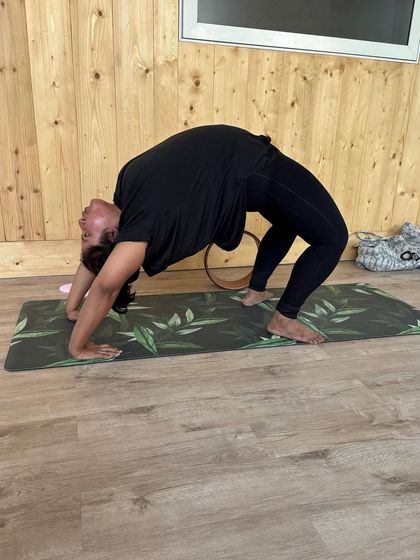 A member works on her wheel pose, demonstrating the strength and flexibility that can be built through consistent yoga practice.