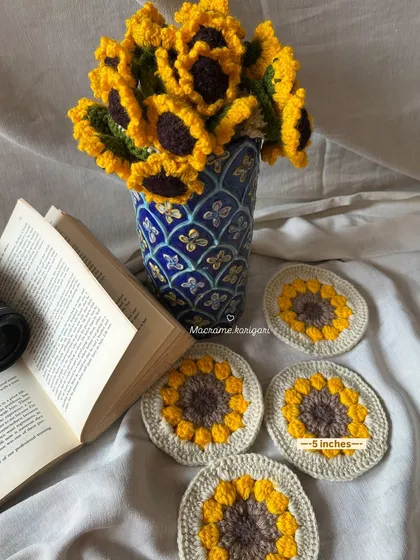 A beautiful still life of our crochet sunflowers in a vase, paired with matching coasters. This shows how you can coordinate our floral items with other decor.