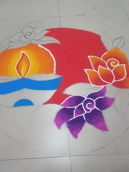 An in-progress view of a circular Diwali rangoli. You can see the pencil outlines that guide the design and how the colors are blocked in before fine details are added.