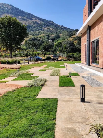 A geometric pattern of stone pavers and lawn creates a modern, graphic look for this outdoor space. The integrated pathway lighting ensures the area is safe and visually appealing even after dark, highlighting the clean lines of the design.