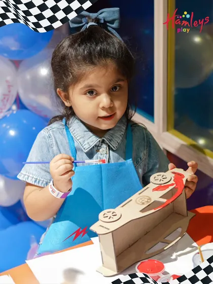It’s not just about play; it’s about creativity! Here, a young guest is completely focused on painting her own wooden car during our Mini Racers event. I provide all the materials for these fun DIY craft activities.