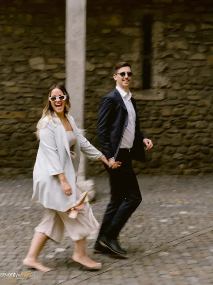 A candid, motion-blurred shot of them walking barefoot on cobblestone streets. It captures their carefree spirit and the joyful energy of their day in a historic Swiss town.