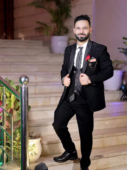 A full-length shot of the groom looking dapper and ready for the celebration. His confident smile and stylish suit are perfectly captured.