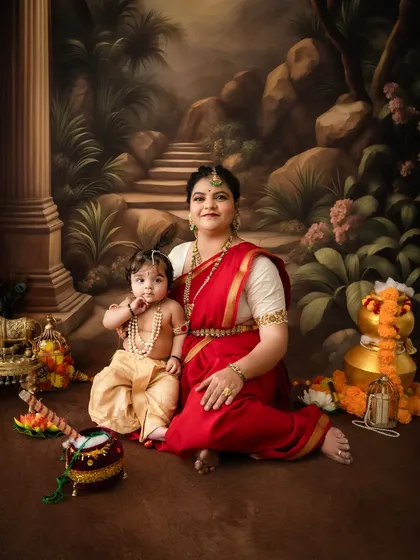 A wide shot of the mother and child in a forest-themed setting, surrounded by traditional props like a flute, matki, and brass decor.