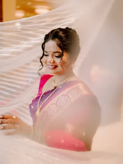 An artistic shot of the bride, her smile shining through a delicate veil.