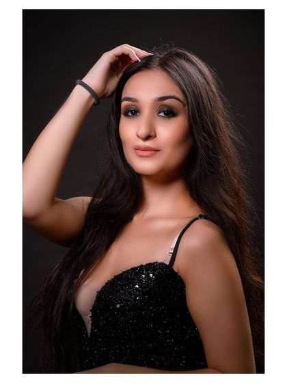 A glamorous studio portrait in a sparkling black dress. The model's pose is elegant and sophisticated.