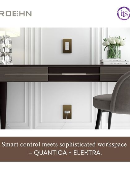 The Roehn QUANTICA keypad and ELEKTRA accessories are shown in a sophisticated workspace, featuring a bronze finish that complements the modern desk setup.