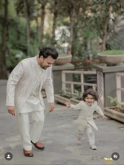 Capturing a beautiful moment between a father and son, both dressed in our coordinated off-white sherwanis. We specialize in creating matching traditional outfits for the entire family, ensuring everyone looks their best.