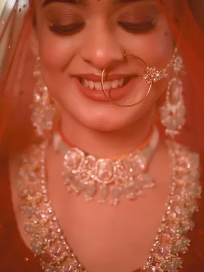 An extreme close-up on the bride's smile and her traditional nath. This shot is all about capturing the pure, unfiltered joy of the moment.