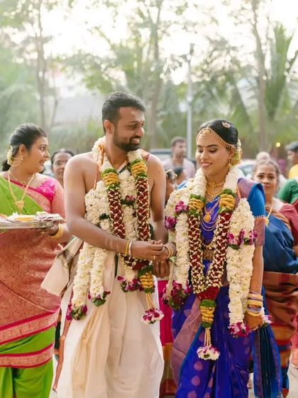 The bride and groom, accompanied by their family, walk together during their traditional Tamil wedding procession.