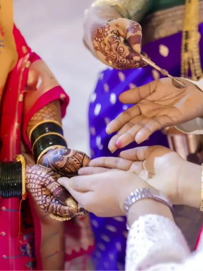 A close-up of a wedding ritual involving the hands of the bride and groom, a moment rich with symbolism and tradition.