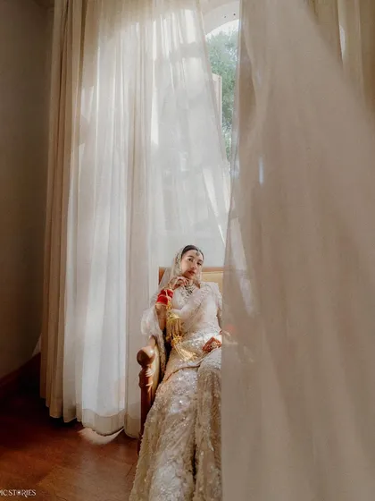 A creative use of foreground to add depth to a bridal portrait. The flowing curtain creates a sense of intimacy, as if we are getting a private glimpse of the bride in a quiet moment.