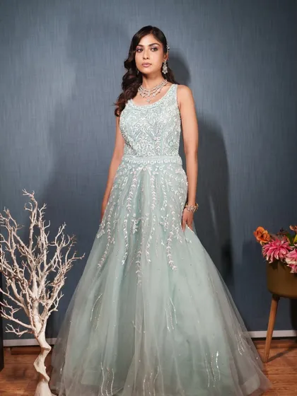 A professional shot of a model in our mint green sleeveless gown. The delicate silver embroidery looks like frost on the dress.