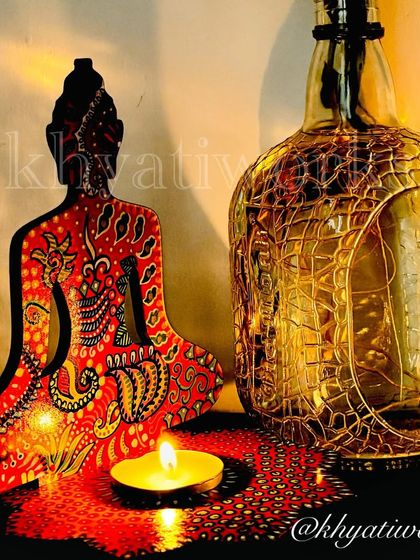 A hand-painted Buddha candle holder in red and yellow tones, creating a warm and inviting glow. It's a perfect centerpiece for meditation or relaxation.