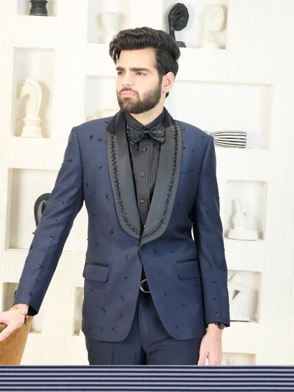 A framed version of the navy blue tuxedo with beaded lapels, presented as a work of art. This highlights the design's status as a piece of wearable luxury.
