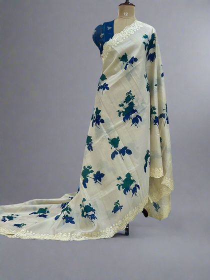 A beautiful Kota checks saree with blue and green floral prints and a delicate lace border, draped on a mannequin.