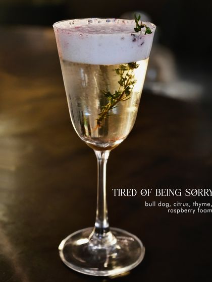 Tired of Being Sorry, a complex and aromatic gin cocktail from our Valentine's menu. It features Bulldog gin, citrus, thyme, and a delicate raspberry foam.