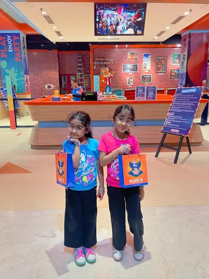 Two happy visitors with their goody bags after a fun day of play.