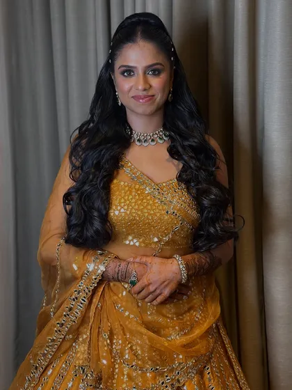 A close-up of the bride's sangeet look, showing her beautiful wavy hair and glowing makeup.