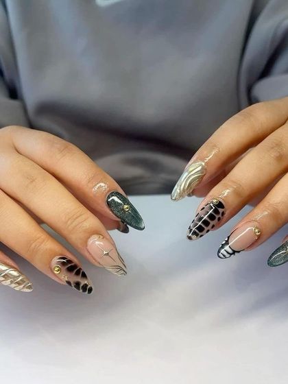 A creative mix of textures and patterns. These stiletto nails feature crocodile print, cat-eye effect, and gold chrome for a truly unique set.