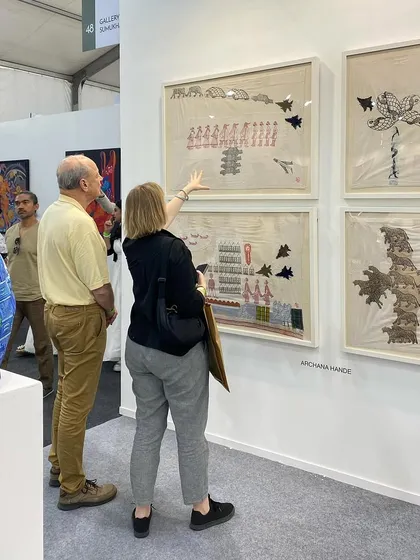 A visitor explaining Archana Hande's work to her companion.