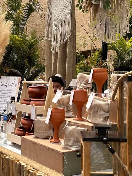 This shot shows the layers of our boho decor, from the bamboo-lined bar front and macrame hangings to the rustic wooden crates and terracotta glasses.