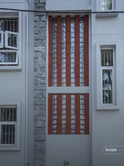 A facade detail showing a vertical panel of glass blocks and terracotta, designed to let in diffused light while maintaining privacy.