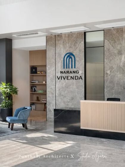 The company's branding is integrated directly into the architecture with the logo prominently displayed on the marble feature wall behind the reception desk.