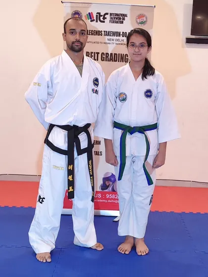 A female student poses after her belt grading. She has demonstrated excellent technique and a strong martial arts spirit.