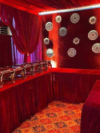 Even the food service area was part of the design. I used red velvet draping and a curated collection of decorative silver plates on the wall to maintain the opulent theme.