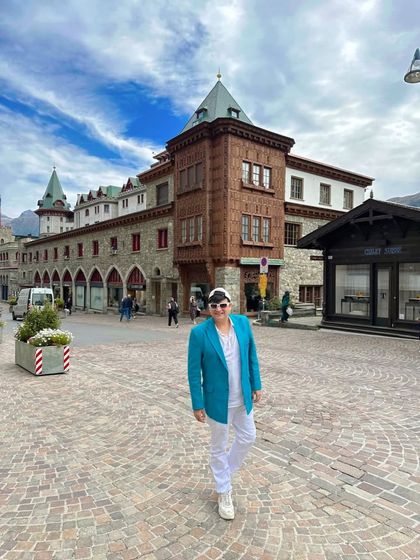 Exploring the charming streets of St. Moritz, Switzerland. My turquoise blazer adds a pop of color against the classic European architecture.