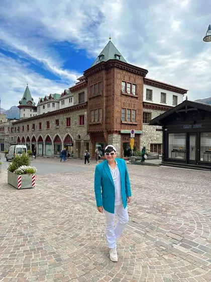 Exploring the charming streets of St. Moritz, Switzerland. My turquoise blazer adds a pop of color against the classic European architecture.
