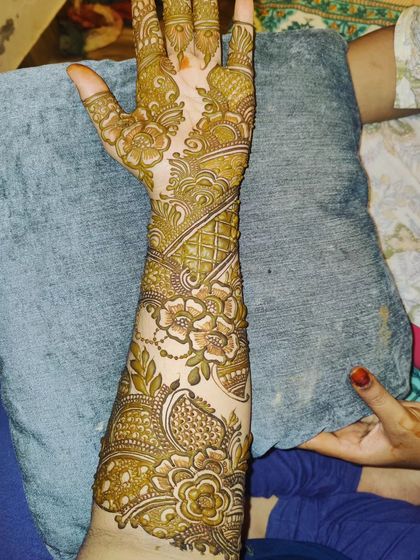 A full-arm party henna design that is both bold and beautiful. The combination of thick vines and delicate floral chains creates a balanced and eye-catching look.