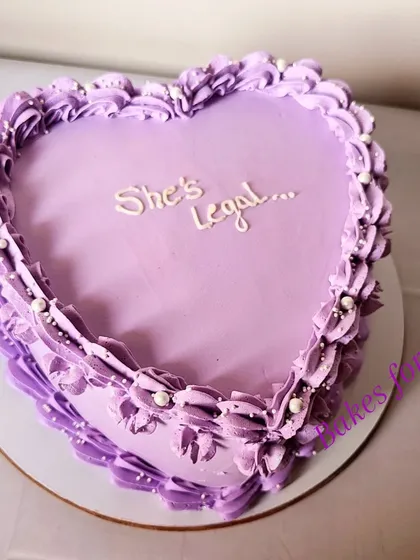 "She's Legal." A stylish heart-shaped cake in a lovely lavender color to celebrate an 18th birthday. The vintage piping adds a touch of elegance.