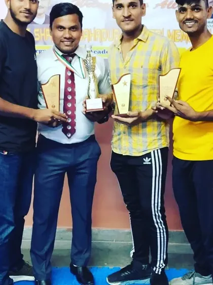 The coaching staff and senior players with the trophies and plaques won at the tournament.