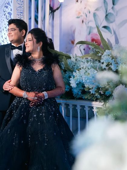 A wide shot showing the couple amidst the beautiful floral decorations of their engagement venue. We capture both the intimate moments and the grander setting of your event.