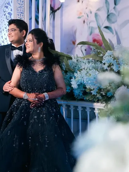 A grand reception portrait of a couple amidst beautiful floral decorations.