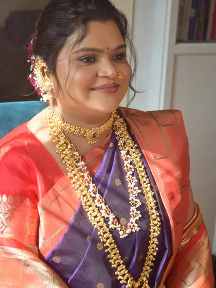 Another beautiful portrait, capturing the soft, well-blended makeup and the intricate details of her gold jewelry.