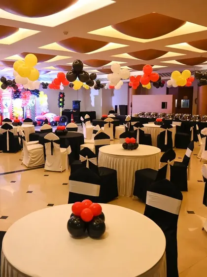 An overview of the Ferrari-themed party room, with tables dressed in black and white and red balloon centerpieces to match the high-speed theme.