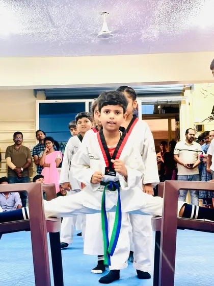 Flexibility is as important as strength in Taekwondo. This student demonstrates incredible dedication and control, achieving a full split between two chairs.
