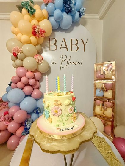 This "Baby in Bloom" cake was the star of the party, set against a beautiful balloon arch. The cake itself is adorned with delicate, hand-piped buttercream flowers, fitting the joyful theme perfectly.