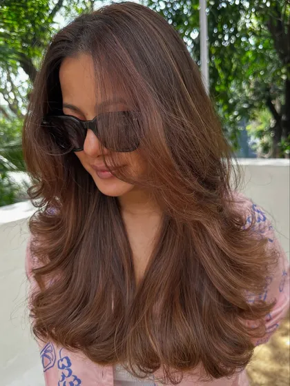 Nothing screams confidence like freshly colored hair. We went for a rich chocolate brown with subtle highlights, styled with big, bouncy waves for a glamorous finish.