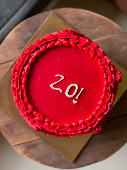 A top-down view of the bold red 20th birthday cake.